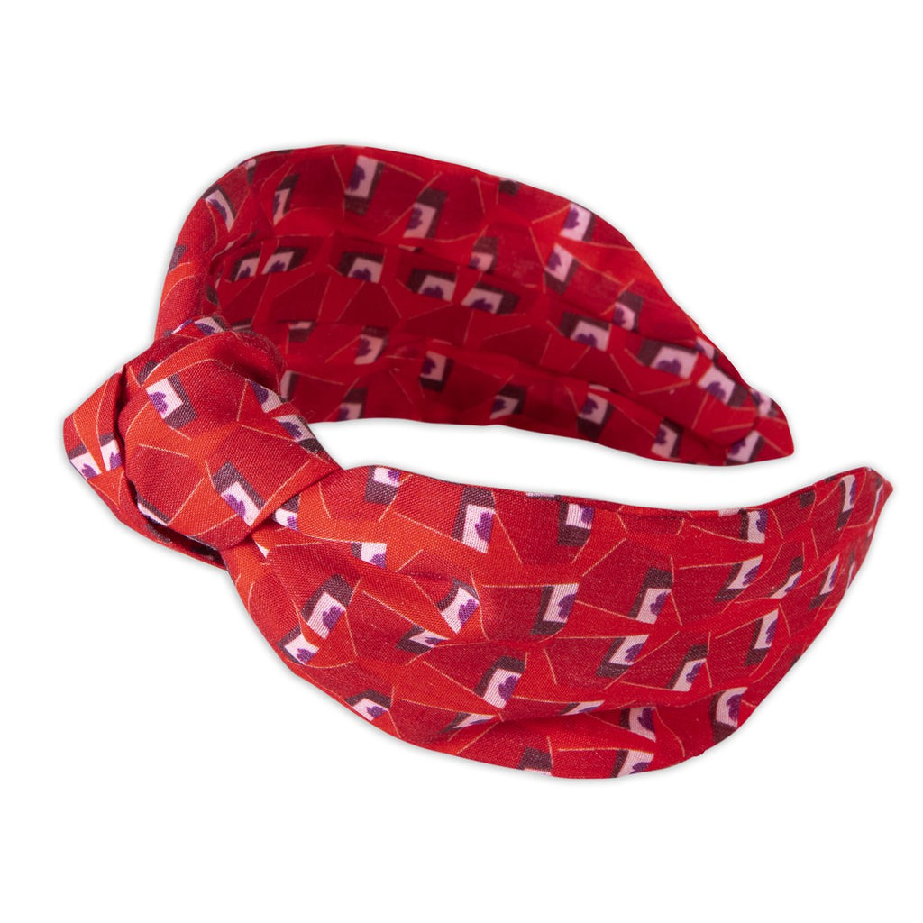 A Kate Whyley wide, knotted headband with a red, burgundy and white pattern, called Hot Lips