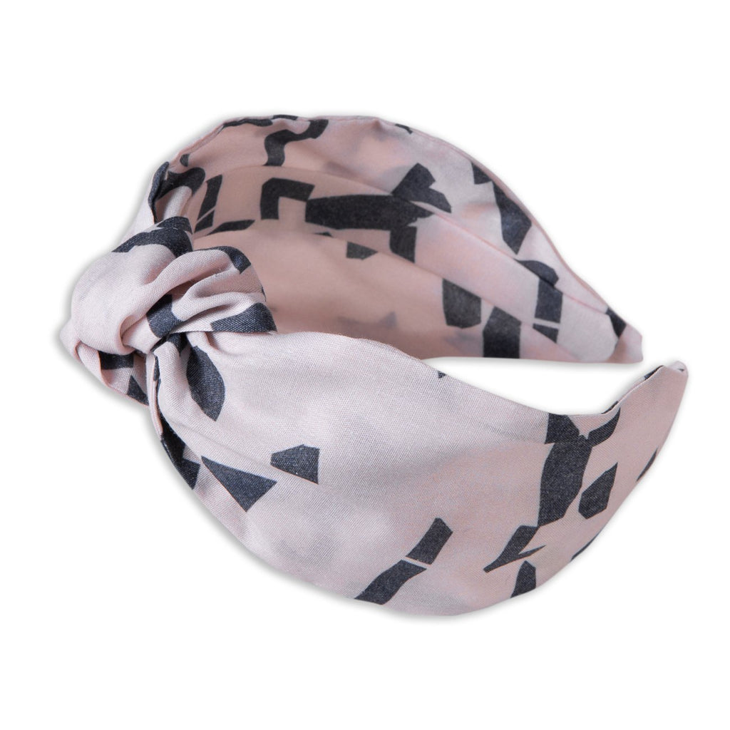 A Kate Whyley wide, knotted headband in blush pink and dark grey, called Direction