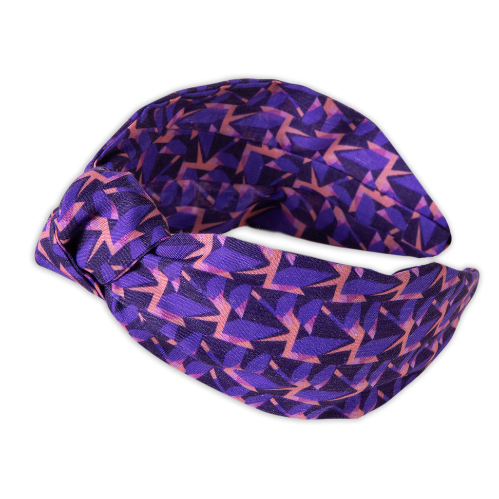 A Kate Whyley wide, knotted headband with a purple and pink pattern, called Nitesky