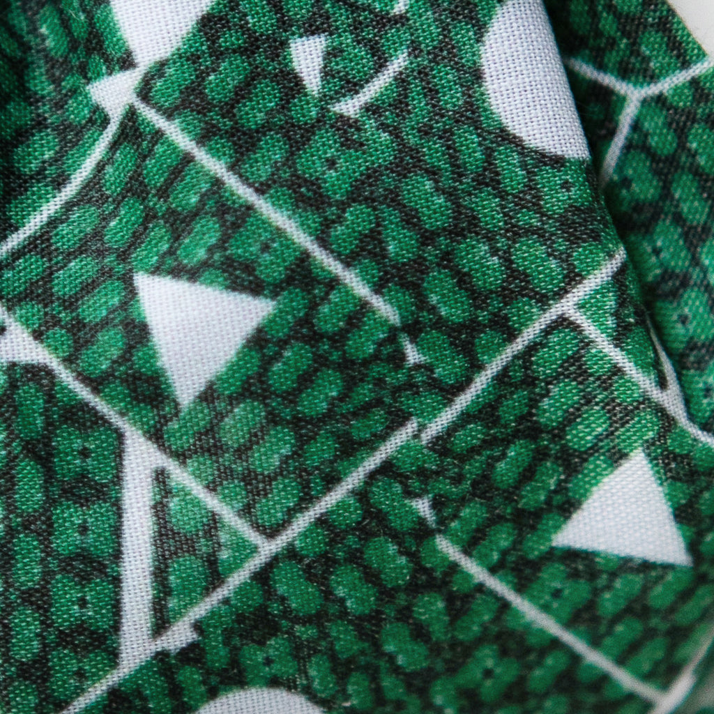 A close up image of Kate Whyley wide, knotted headband cotton fabric with a green and white pattern, called Topiary