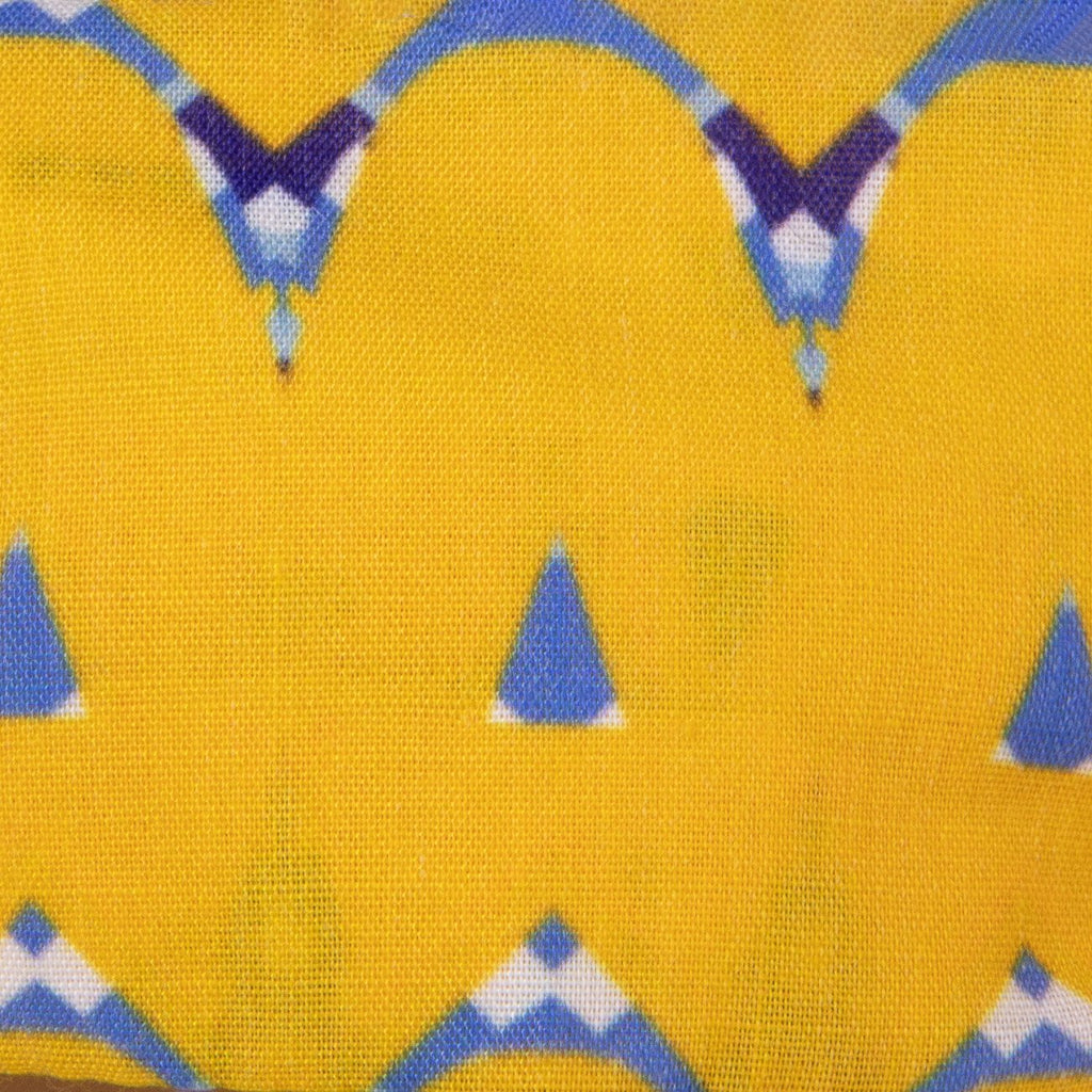 A close up image of Kate Whyley wide, knotted headband cotton fabric, with a yellow, blue and white and pattern, called Holding Hands