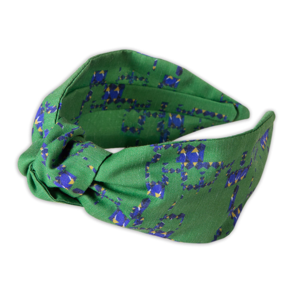 A Kate Whyley wide, knotted headband with a green, yellow and blue pattern, called Vert Amor